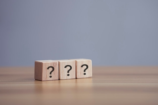 Questions Mark word in wooden cube block on table background