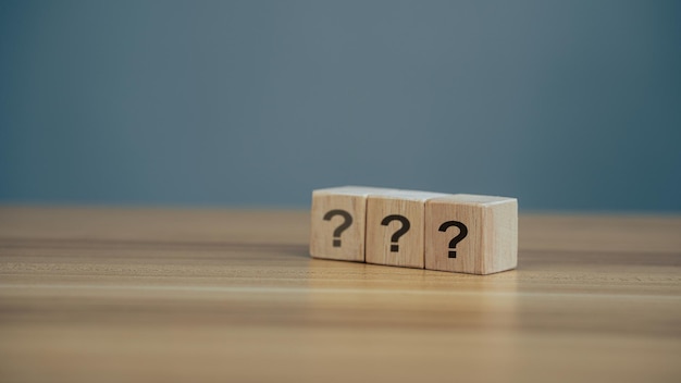 Questions Mark word in wooden cube block on table background