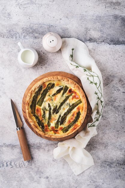 Quiche Homemade asparagus pie or quiche with cheese pecorino bacon and spinach on gray concrete light table background Asparagus and cheese tart French Quiche Top view