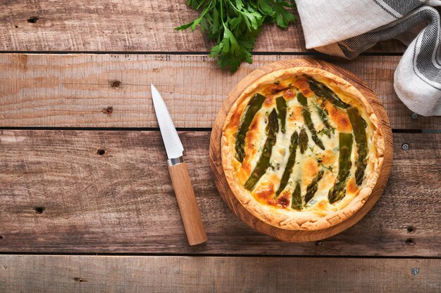 Quiche torta di asparagi fatta in casa o quiche con formaggio e spinaci su sfondo di un vecchio tavolo in legno torta di asparagi e formaggio quiche francese vista dall'alto