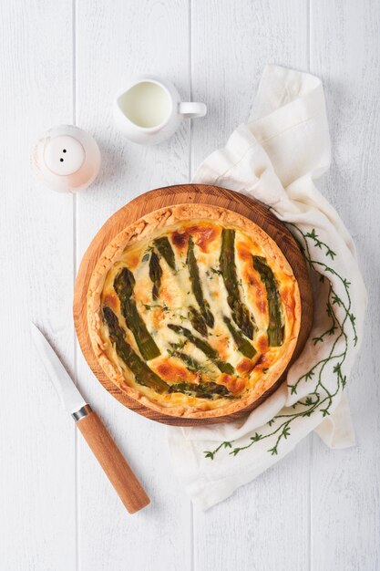 Quiche Homemade asparagus pie or quiche with cheese and spinach on white wooden table background Traditional French Quiche Top view