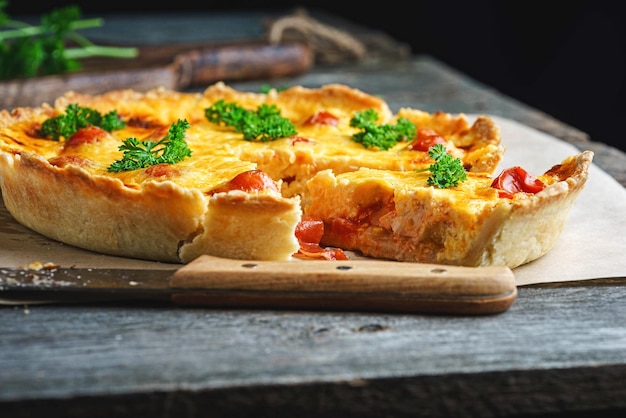 Quiche lauren cheese vegetable pie with chicken on a wooden table