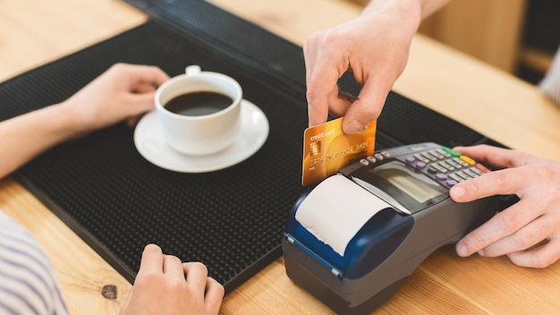 Quick and easy payments. Close up of transaction with credit card in cafe for coffee