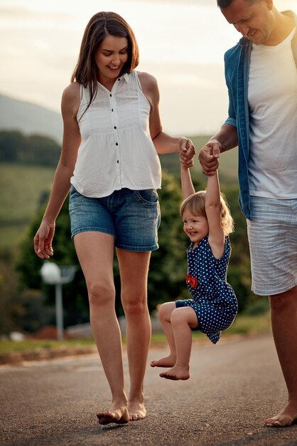 Foto veloce e divertente passeggiata nel quartiere inquadratura di una giovane famiglia che cammina insieme nel quartiere