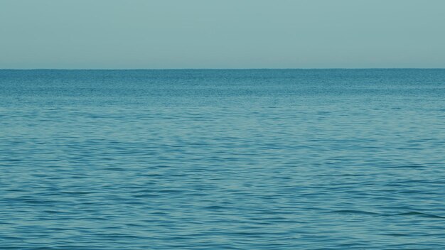 Foto texture silenziose del paesaggio marino con piccole onde e cielo blu limpido splendida vista dal mare