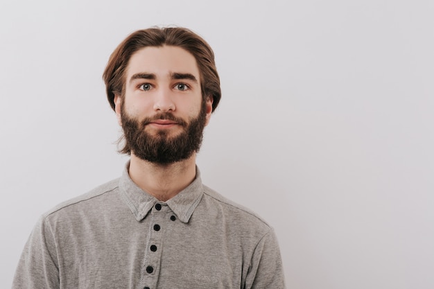 Quiet young man, looking into the camera, studio, isolated space gray, copy space, close-up