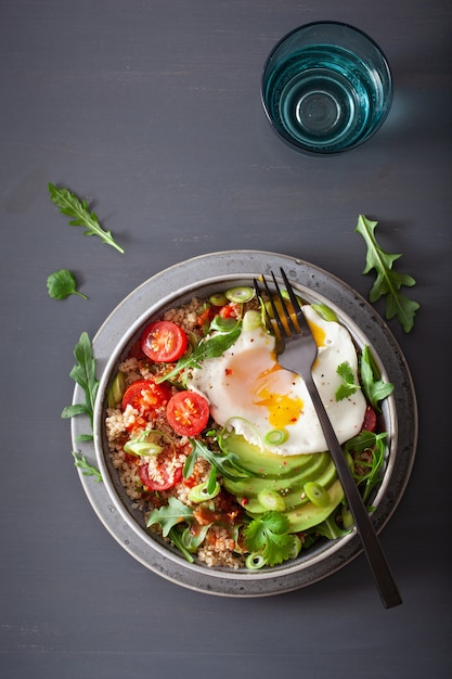 Quinoa bowl with fried egg, avocado, tomato, rocket. healthy vegetarian lunch