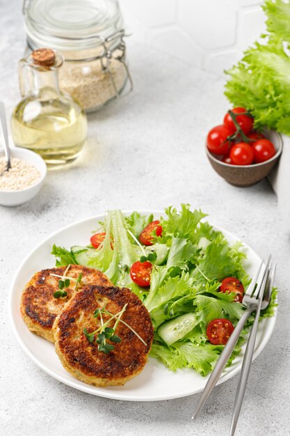 Quinoa cutlets served with lettuce tomatoes microgreens Diet concept Vegan food plate