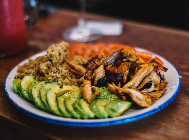 Quinoa dish with avocado tomato and chicken