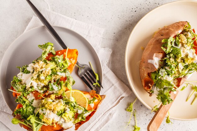 Quinoa gevulde zoete aardappelen met boerenkool en avocado, bovenaanzicht.