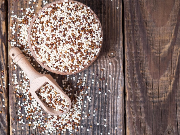 Quinoa in houten kom en schep op rustieke achtergrond