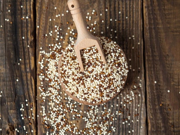 Quinoa in houten kom en schep op rustieke achtergrond