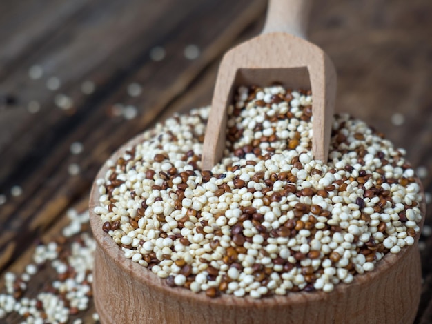 Quinoa in houten kom en schep op rustieke achtergrond