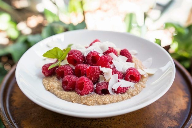 Quinoa porridge met framboos en kokosnotenvlokken voor het ontbijt