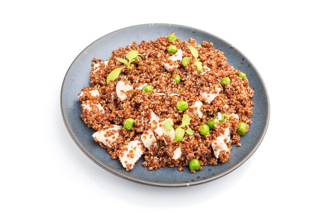 Quinoa porridge with green pea and chicken on ceramic plate