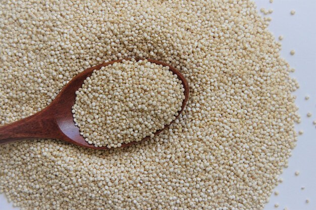 Photo quinoa seed for healthy nutrition with a spoon on a white background