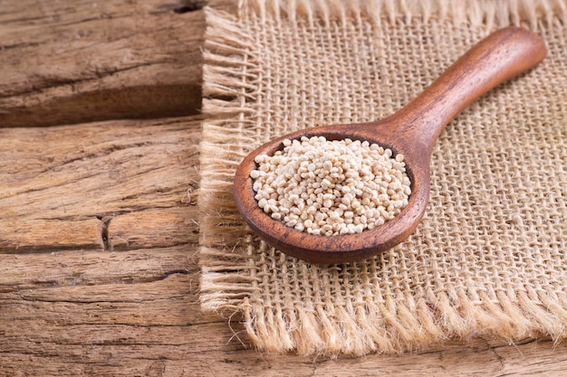 Quinoa seeds in bowl on rustic wood