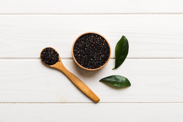 Quinoa seeds in bowl and spoon on colored background Healthy kinwa in small bowl Healthy superfood