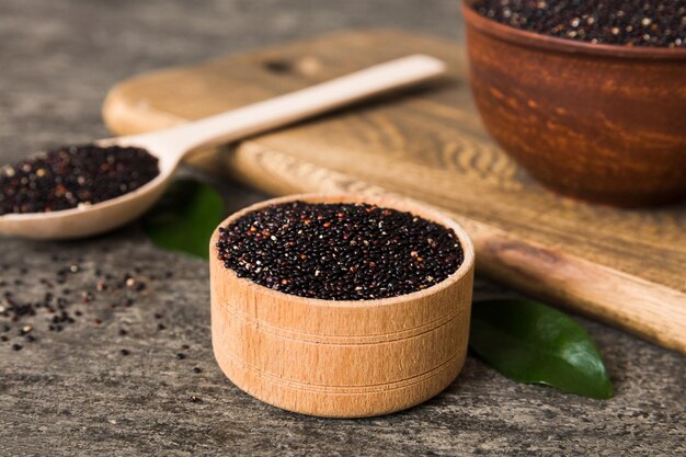 Quinoa seeds in bowl and spoon on colored background Healthy kinwa in small bowl Healthy superfood