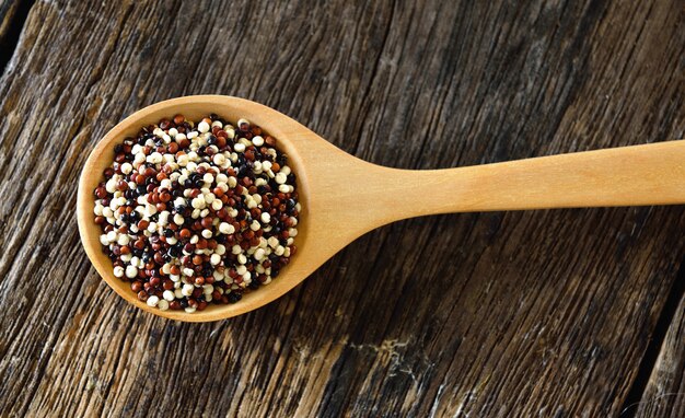 Quinoa seeds in spoon on wood
