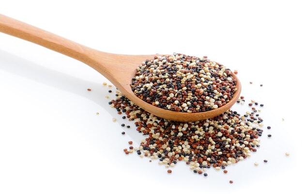 Quinoa seeds in wood scoop on white background