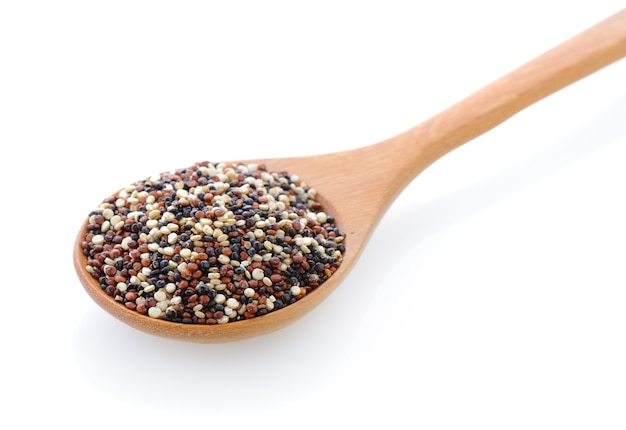 Quinoa seeds in wood spoon on white background