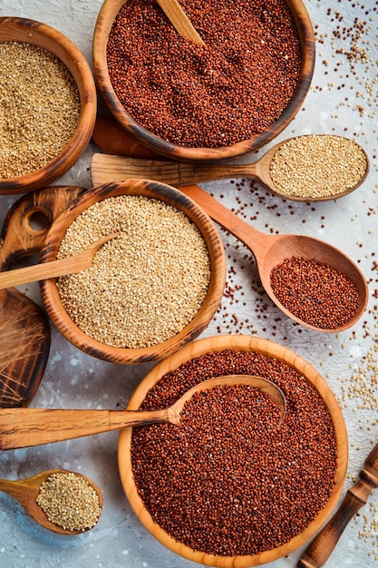 Quinoa set Red, white and brown quinoa. On a black background. Top view. Free copy space.