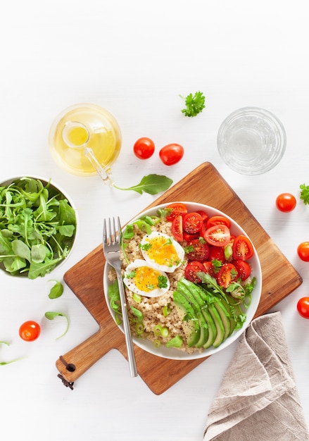 Quinoa with boiled egg, avocado, tomato, arugula. healthy breakfast