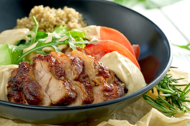 Quinoa with chicken and salad on a black plate Bowl superfood