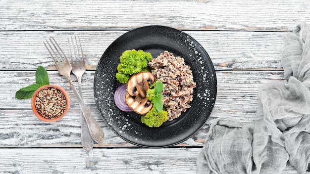 Quinoa with mushrooms and vegetables on a plate Top view Free space for your text