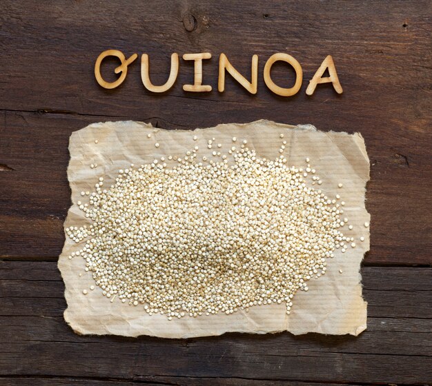 Quinoa and a  word   Quinoa on a brown wooden table top view