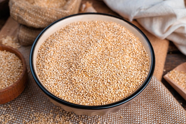 Quinoa zaden in een kom op een houten achtergrond Zijaanzicht close-up