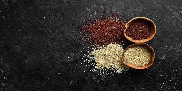 Quinoa zaden op houten keukentafel bovenaanzicht Gezond en dieet superfood product op een zwarte stenen achtergrond