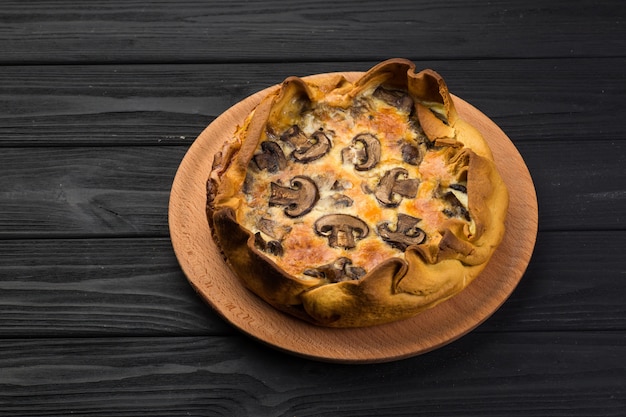 Quishe with mushrooms on a wooden plate