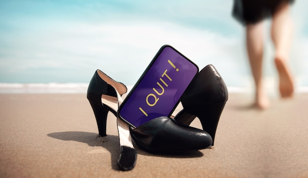 Quit a Job Concept. Business Woman take off Working Shoes and leave it on the Sand Beach for Walk into the Sea. I Quit Message on Mobile Phone. Summer Vacation. Low angle View