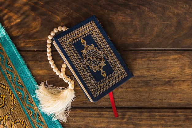 Quran and beads near mat