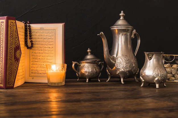 Photo quran and candle near tea set