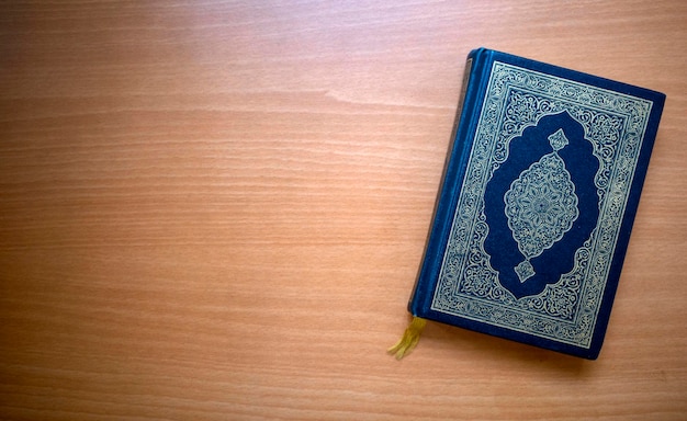 Photo the quran the holy book of muslims on a wooden table