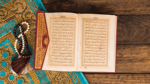 Quran near beads and patterned rag