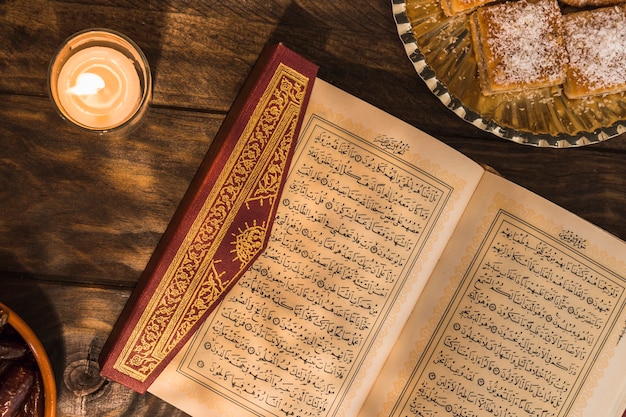 Photo quran near candle and dessert