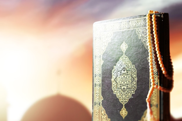 Quran and prayer beads on the table