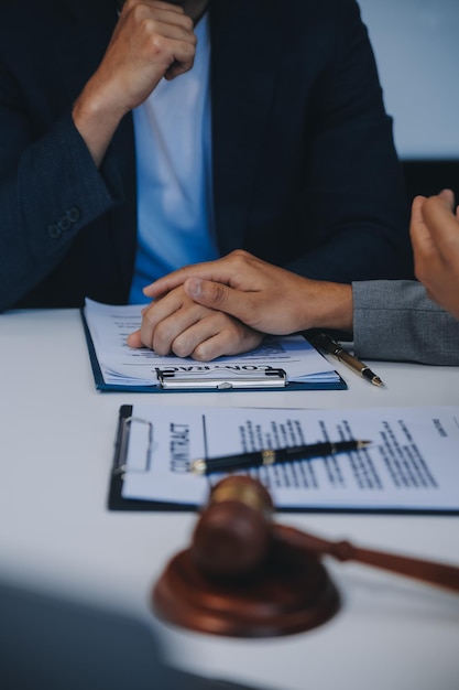 Raadpleging en conferentie van mannelijke advocaten en professionele zakenvrouwen die in een advocatenkantoor werken en bespreking hebben in het kantoor Concepten van de wet Rechter hamer met de weegschaal van de gerechtigheid