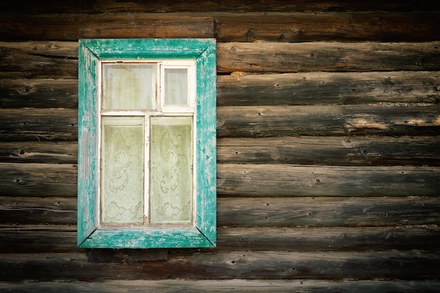 Raam met blauw houten frame in een oud blokhuis afgezwakt