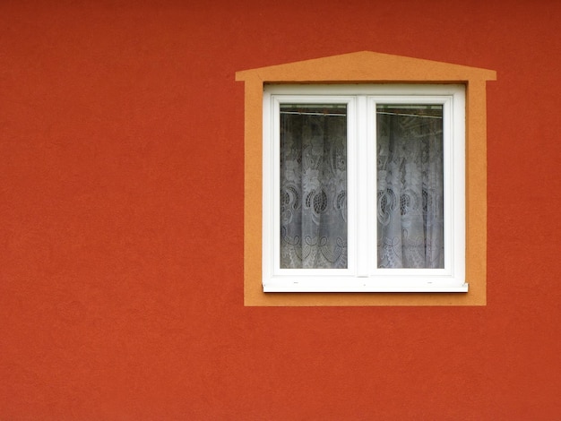 Raam met gordijnen en frame op oranje muur