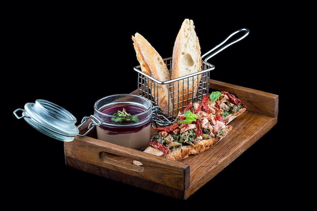 Rabbit pate with bruschetta on a wooden board On dark background