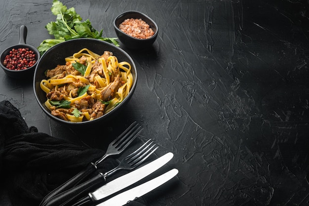 Rabbit stew tagliatelle set, in bowl, on black stone table