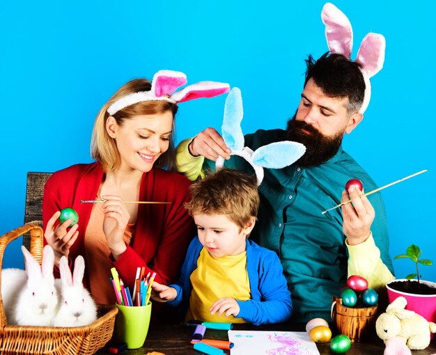 Rabbits family in bunny ears painting eggs for holiday easter egg decorating ideas