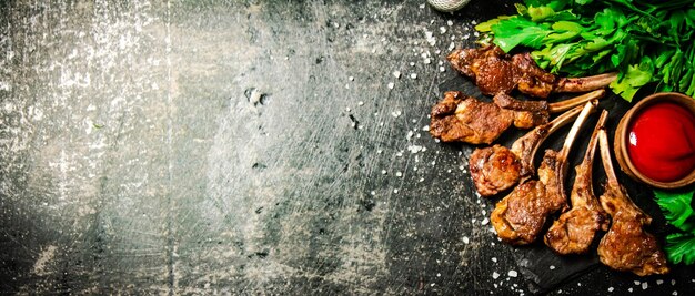 Rack of lamb with tomato sauce and parsley on the table