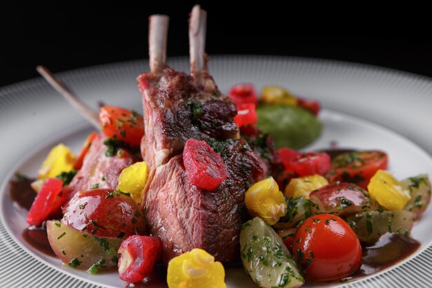 Rack of lamb with vegetables on a white plate