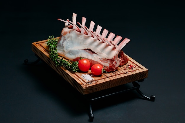 A rack of new Zealand Lamb in raw form on black.